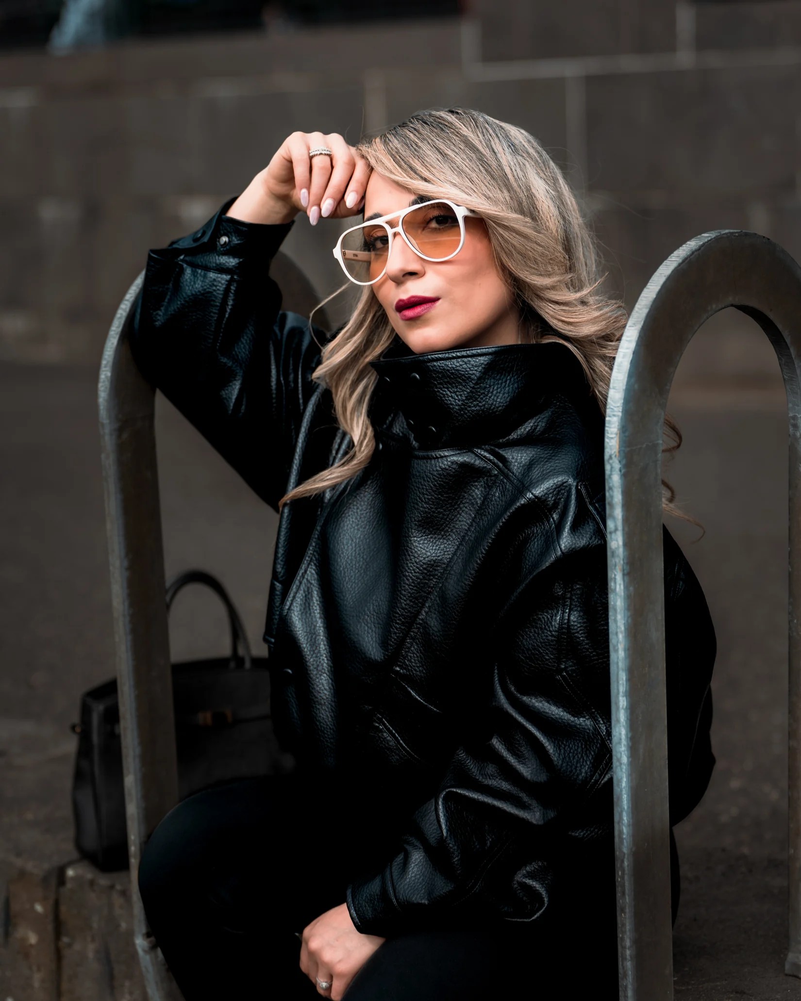 Portrait of Neda wearing a black jacket and white sunglasses